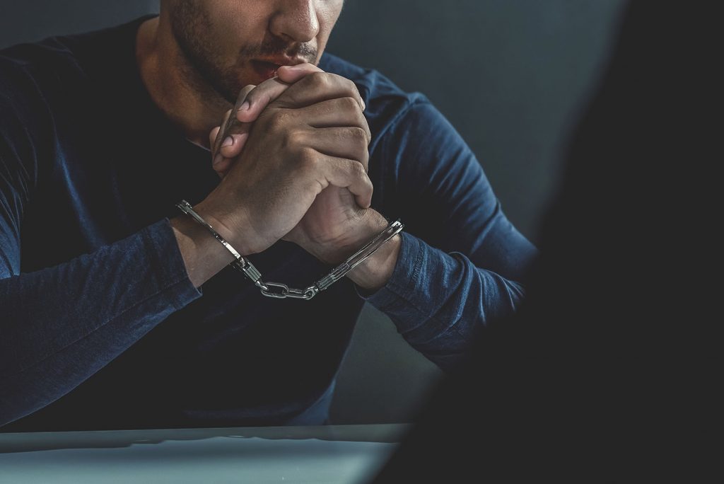 Image of someone consulting their lawyer while in custody.